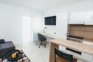 cocina y sala de estar con escritorio y mesa en Comfy Place in Trešnjevka with FREE parking, en Zagreb