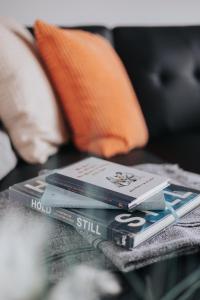 a pile of books sitting on top of a table at Horse Park Hideaway, Luxury Hot Tub Glamping Retreat in Pilling