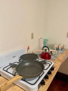 a stove top with two pans on top of it at Rosa - Private room in shared house in Roatan