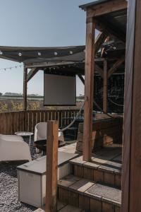 a wooden pergola with a screen on a patio at Horse Park Hideaway, Luxury Hot Tub Glamping Retreat in Pilling