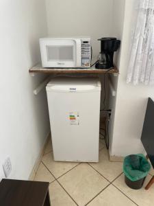 a microwave sitting on top of a refrigerator at Chalé Condominio Linda Vista in Penedo