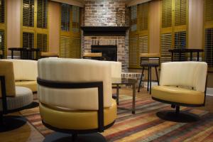 a lobby with two chairs and a fireplace at Holiday Inn Express Savannah - Historic District, an IHG Hotel in Savannah