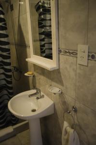 La salle de bains est pourvue d'un lavabo et d'un miroir. dans l'établissement Altavista Aparts, à Colón