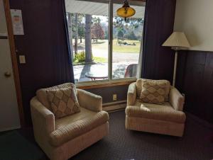 a living room with two chairs and a window at Crossroads motel & cabins in Oxford