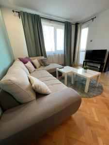 een woonkamer met een bank en een tafel bij Al Malina 3BDR Family Apt with Parking Space near Airport and IEC in Sofia