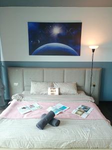 a bed with a pink blanket and a painting on the wall at C1110 Almas Suites Galaxy Space Netflix By STAY in Nusajaya