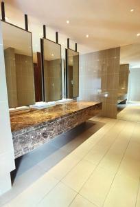 a bathroom with several sinks and mirrors on the wall at Almas Suites 알마스 스위트 갤럭시 스페이스 넷플릭스 바 STAY in Nusajaya