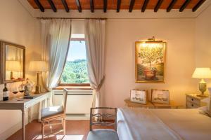 Wine Resort Dievole في Vagliagli: غرفة نوم بسرير ومكتب ونافذة