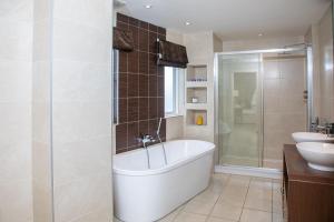 a bathroom with a bath tub and a sink at 20 Golf Place in St. Andrews +16 photos