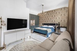 a living room with a tv and a bed at WeHost Marble and Brands in the Heart of Helsinki @Vuorikatu 8 in Helsinki