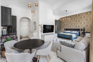 a living room with a bed and a table and chairs at WeHost Marble and Brands in the Heart of Helsinki @Vuorikatu 8 in Helsinki