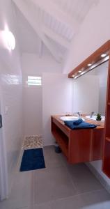 une salle de bains blanche avec un lavabo et un miroir dans l'établissement Villa Blue Horizon, à Deshaies
