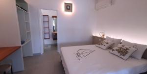 une chambre blanche avec un lit avec des draps et des oreillers blancs dans l'établissement Villa Blue Horizon, à Deshaies