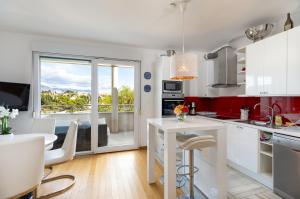 a kitchen with white cabinets and a large window at Marina Lux Split in Split