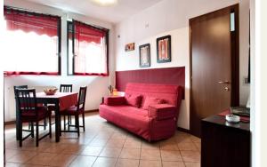 salon z czerwoną kanapą i stołem w obiekcie Il Giacinto w Mediolanie