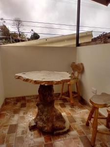 a table with a tree stump in the corner of a room at Posada Martha Tolima in Salento