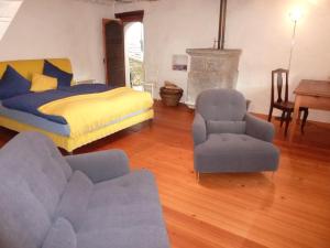 sypialnia z łóżkiem, krzesłem i kanapą w obiekcie Ferienhaus Turilji w mieście Albinen