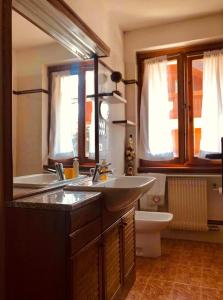 ein Badezimmer mit zwei Waschbecken und einem WC in der Unterkunft Appartamento Il nido in Carisolo