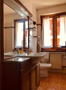 a bathroom with two sinks and a toilet at Appartamento Il nido in Carisolo