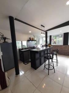 a kitchen with a counter and stools in a room at Hospedaje Finca Agroturistica Doña Rufa in Río Sereno