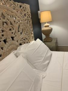 a bed with white sheets and a lamp on a table at Ca' di Giò in Venice