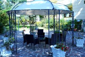 a gazebo with a table and chairs and flowers at HOTIDAY Resort Fiuggi in Fiuggi