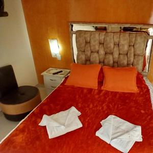 a bedroom with a red bed with two white towels on it at Posada Martha Tolima in Salento