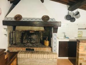 einen gemauerten Kamin in einer Küche mit Spüle in der Unterkunft Tenuta Acquabona - Appartamento 1 in Gambassi Terme