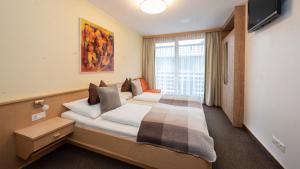ein Hotelzimmer mit einem Bett und einem großen Fenster in der Unterkunft Apart Albore in Ischgl