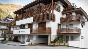 un edificio con balcones de madera en un lateral en Apart Albore, en Ischgl