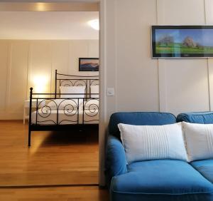 a living room with a blue couch and a bed at Gasthof zur Waag in Bad Zurzach