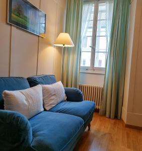 a blue couch in a living room with a window at Gasthof zur Waag in Bad Zurzach