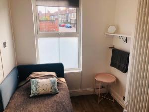 um pequeno quarto com uma cama e uma janela em Nice bedroom close to the train station and the city centre em Norwich