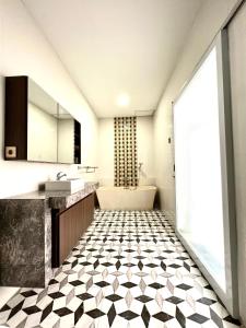 uma casa de banho com piso em azulejo preto e branco em Daniswara Villa em Uluwatu