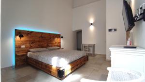 a bedroom with a bed with a wooden headboard at ''B&B Santa Rita Corato fitta camere'' in Corato +26 photos