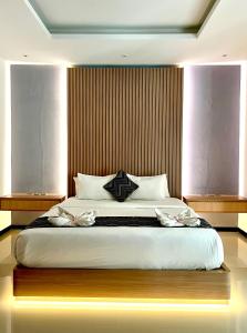 a bedroom with a large bed with a wooden headboard at Daniswara Villa in Uluwatu