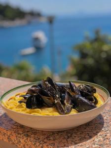 a bowl of food with mussels on pasta on a table at Casa Santo e Albina Rabac in Rabac