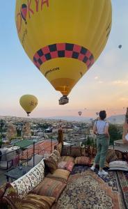 Kobieta stojąca na balonie z gorącym powietrzem w obiekcie Castle Cave Hotel w Göreme