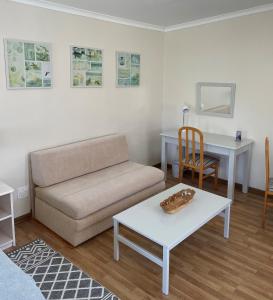 a living room with a couch and a table at Bob-Bob's Cottage in Cape Town