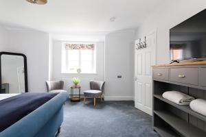 a bedroom with a bed and a mirror and a window at Cloisters Cottage in Chichester