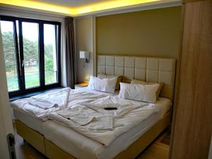 Cette chambre comprend un grand lit et une grande fenêtre. dans l'établissement Avella "Sundowner" mit Meerblick, Innenpool und eigener Wallbox, à Binz