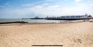 a sandy beach with a pier in the ocean at MV18 Park Holidays, St Osyth Beach no smoking self catering holiday in Saint Osyth