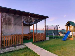 een huis met een speeltuin met een glijbaan bij CASA VIKI in Bănicel