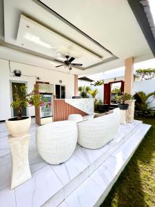 a patio with white chairs and potted plants at Daniswara Villa in Uluwatu