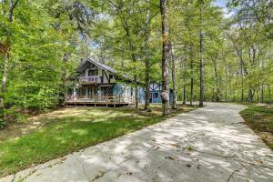 a house in the woods with a driveway at Charming Gaylord Getaway about 2 Mi to Golfing in Gaylord