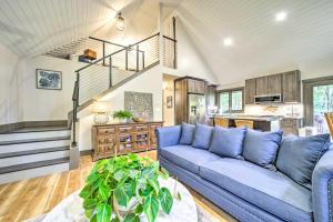 ブレバードにあるChic Brevard Cabin - Nature, Trails, and Water!の青いソファと階段のあるリビングルーム