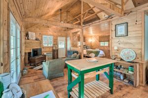 eine Blockhütte mit einem Tisch im Wohnzimmer in der Unterkunft Idyllic Cabin with Fire Pit, Kayak On-Site! in Bells