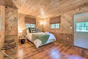 a bedroom with a bed in a wooden cabin at Idyllic Cabin with Fire Pit, Kayak On-Site! in Bells