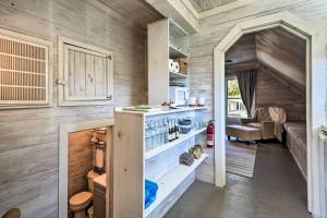 een tiny house met een keuken en een woonkamer bij Unique Loft Cabin Fire Pit and Fishing Access! in Bells