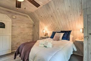 Un dormitorio con una cama grande en una pared de madera. en Unique Loft Cabin Fire Pit and Fishing Access!, en Bells
